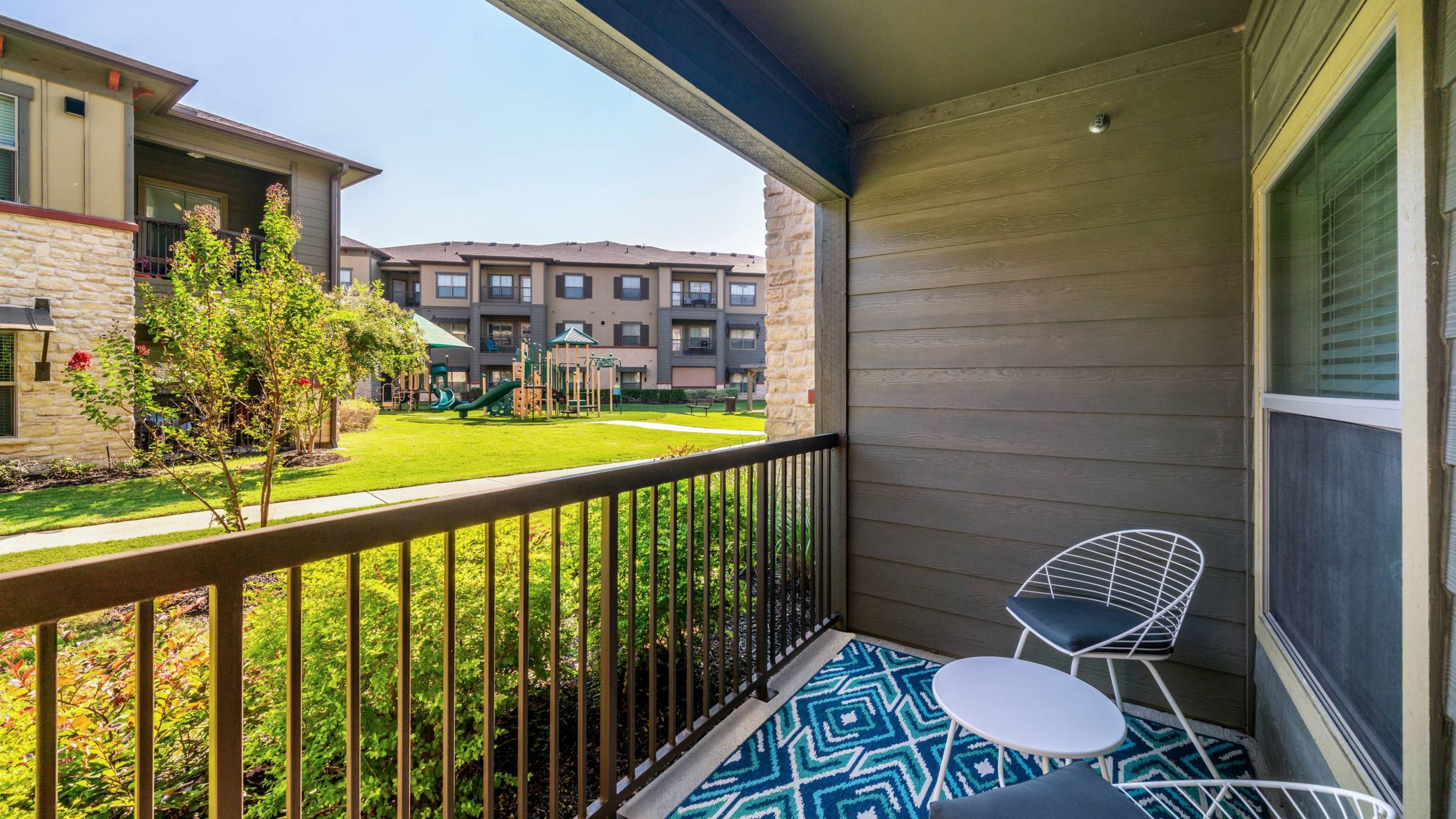 Hawthorne at Crenshaw apartment balcony overlooking a green space and playground