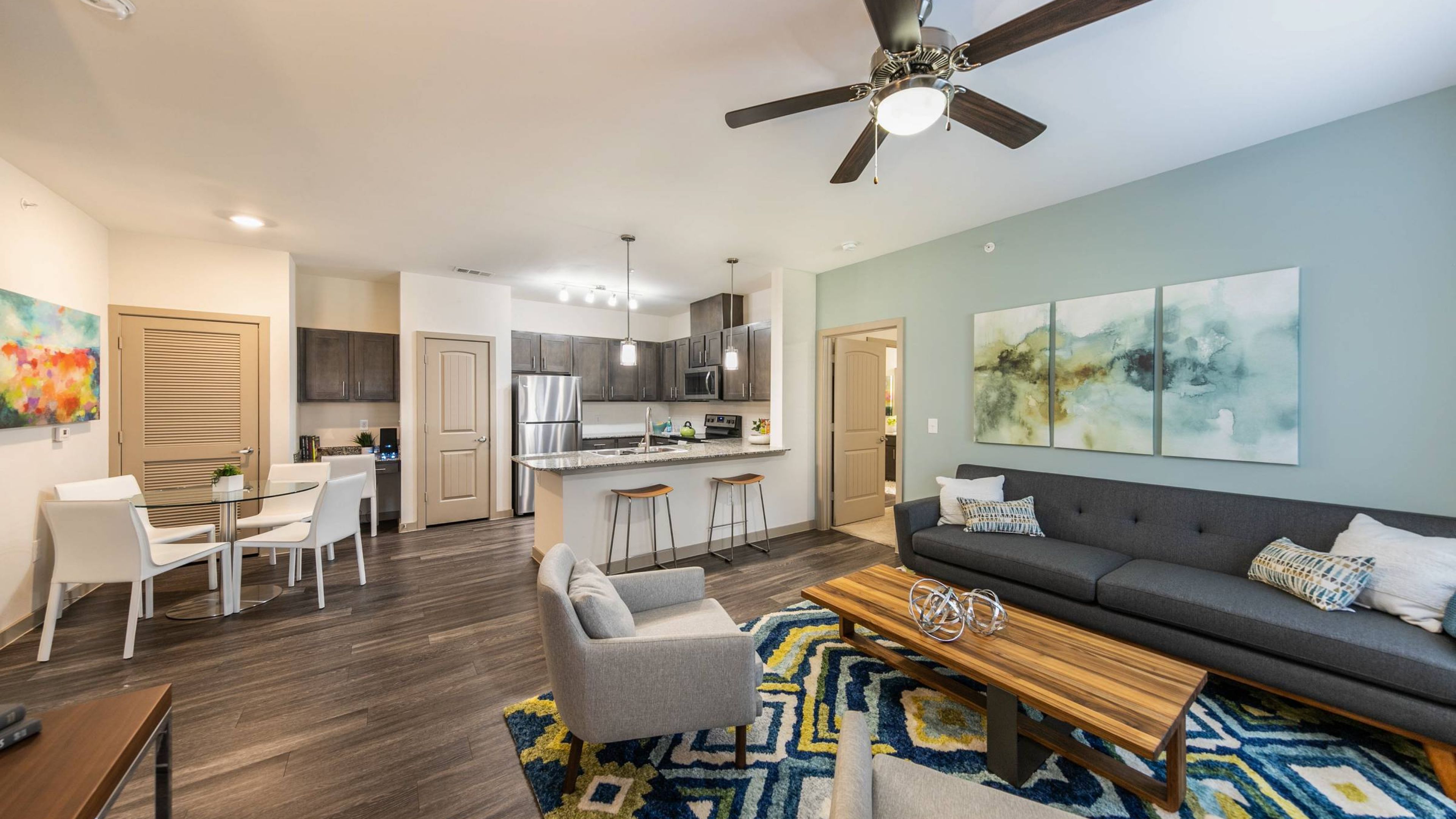 Hawthorne at Crenshaw apartment kitchen and living room furnished with a couch, coffee table, and chair