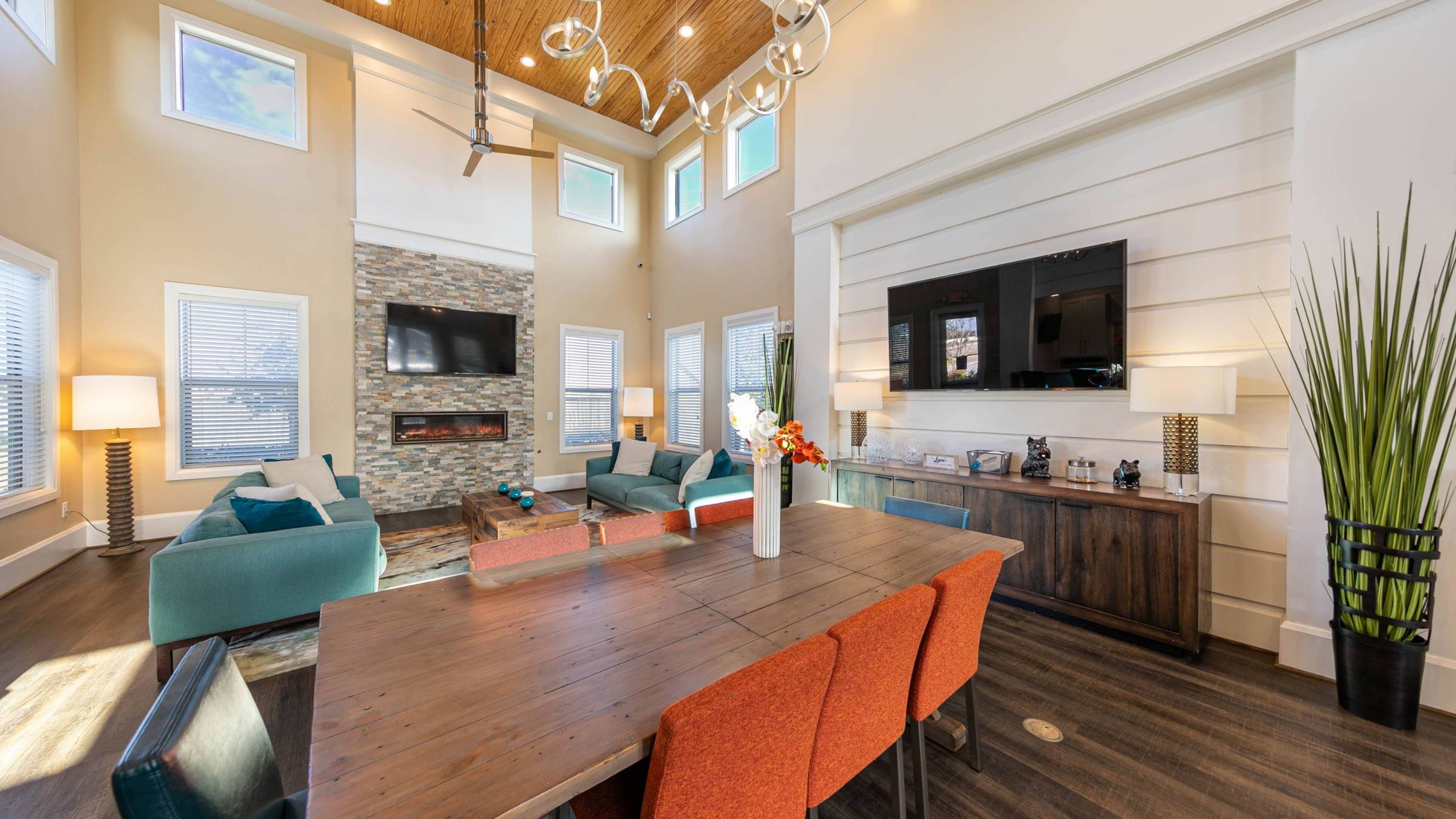Hawthorne at Crenshaw resident clubhouse with fireplace, seating, and large screen TV